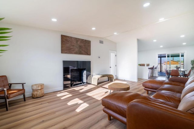 living room with lofted ceiling and light hardwood / wood-style flooring