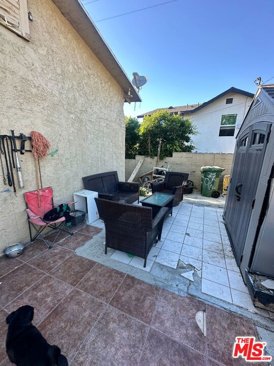 view of patio with outdoor lounge area and a storage shed