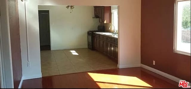 kitchen featuring sink, light tile patterned floors, and range