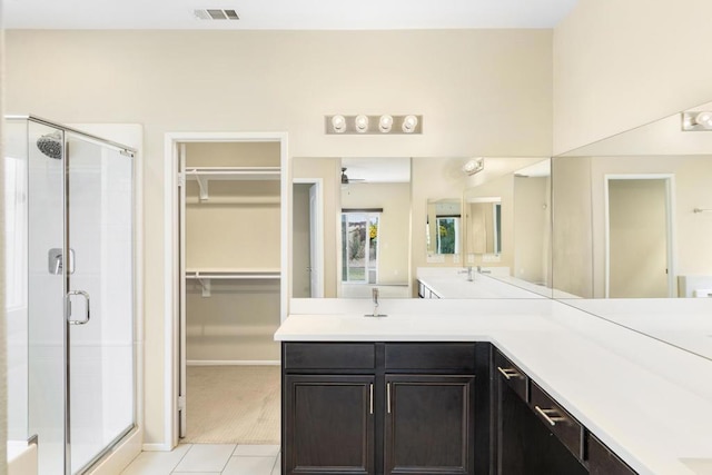 bathroom with tile patterned floors, ceiling fan, and a shower with door