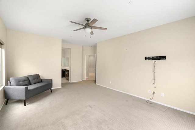 living area with light carpet and ceiling fan