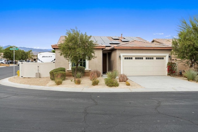 view of front of property featuring a mountain view, a garage, and solar panels