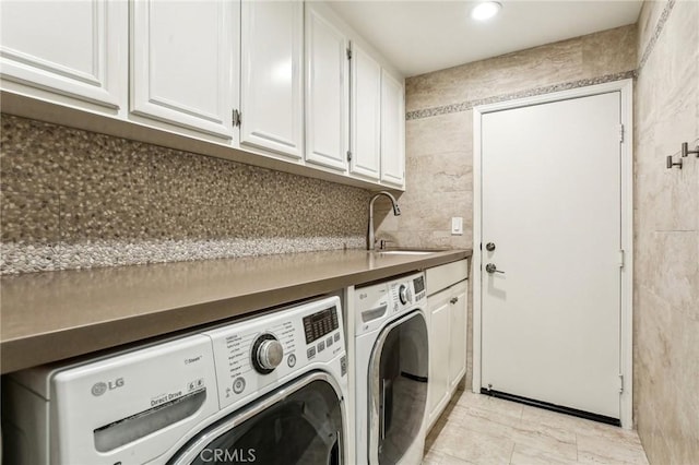 washroom featuring separate washer and dryer, sink, and cabinets