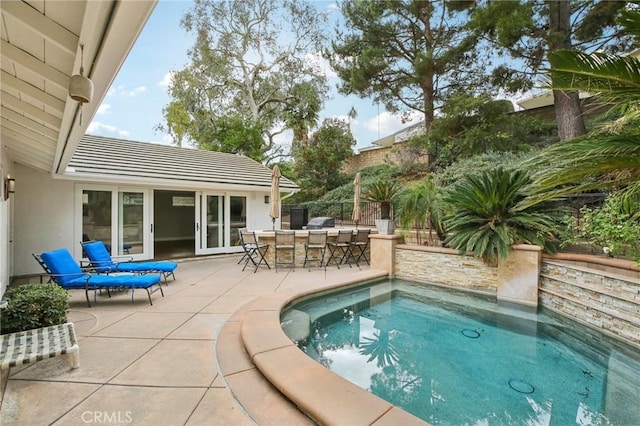 view of swimming pool with an outdoor bar and a patio area