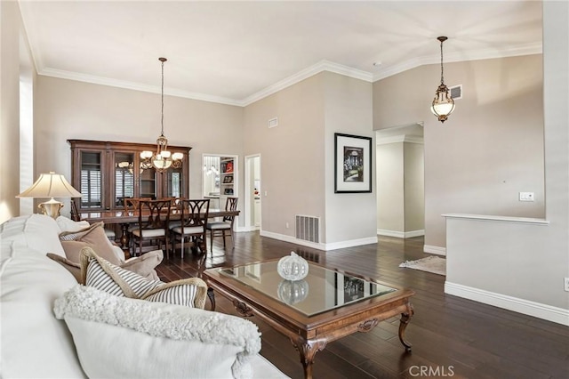 living room featuring a notable chandelier, dark hardwood / wood-style floors, and ornamental molding