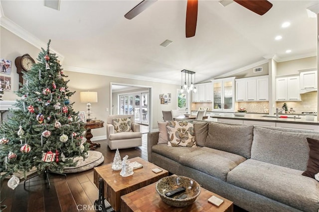 living room with dark hardwood / wood-style floors, vaulted ceiling, and ornamental molding