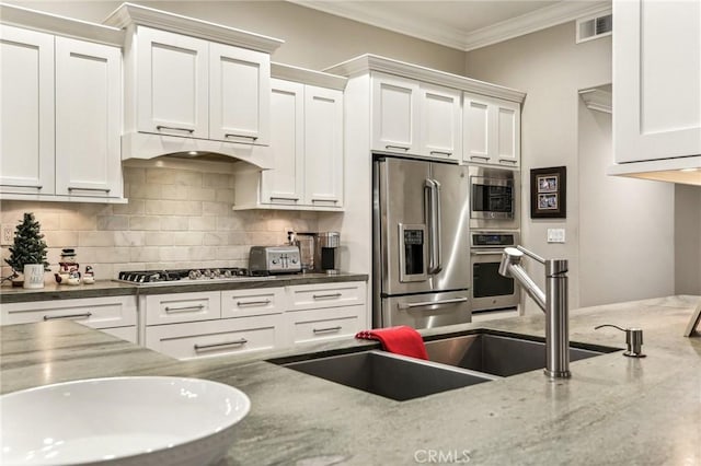 kitchen featuring white cabinets, ornamental molding, and appliances with stainless steel finishes