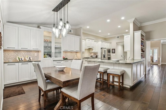 dining space with dark hardwood / wood-style flooring and crown molding