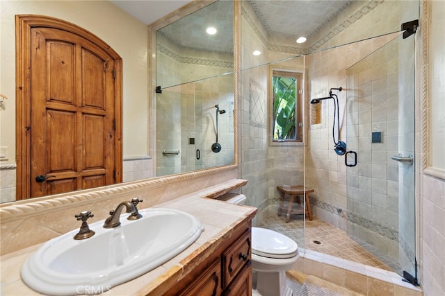 bathroom with toilet, vanity, and walk in shower