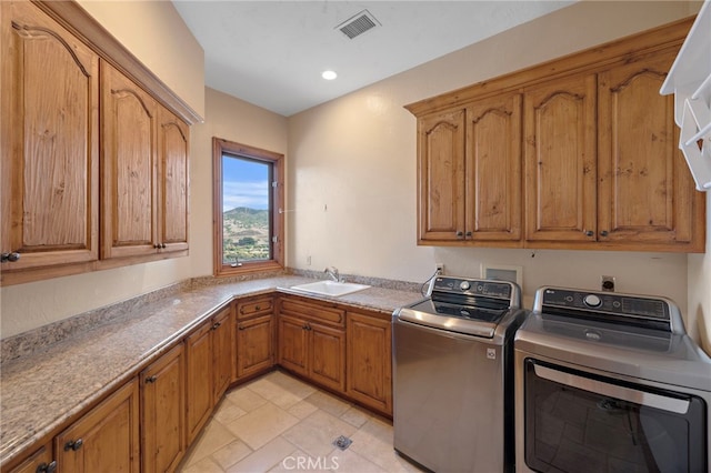 laundry room featuring cabinets, washer and dryer, and sink