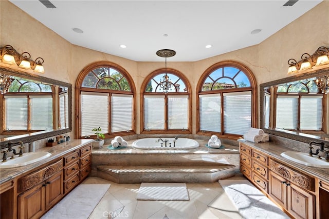 bathroom with tile patterned floors, vanity, and tiled bath