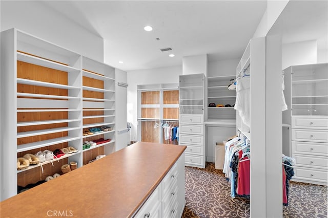 walk in closet featuring dark colored carpet