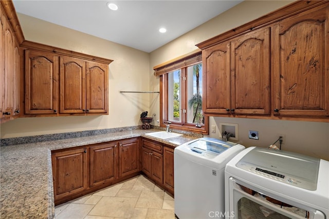 laundry room featuring cabinets, sink, and washing machine and clothes dryer