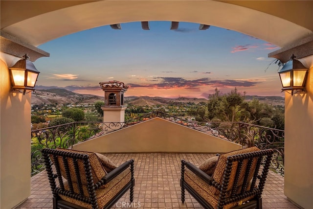 balcony at dusk featuring a mountain view