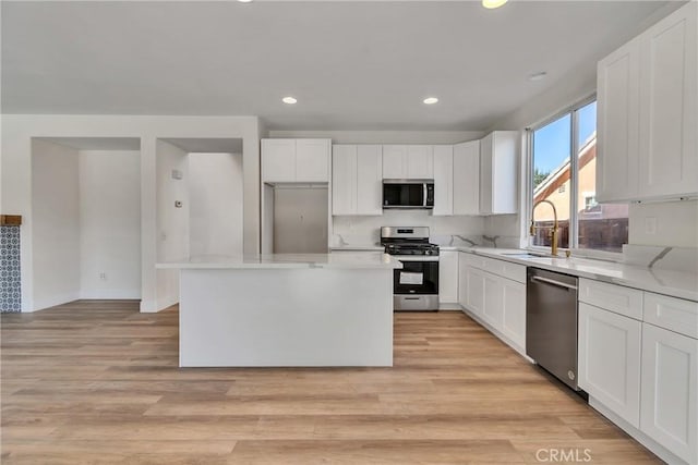 kitchen featuring white cabinetry, sink, a kitchen island, and appliances with stainless steel finishes