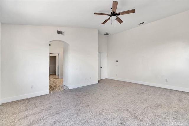 spare room with light carpet, ceiling fan, and vaulted ceiling