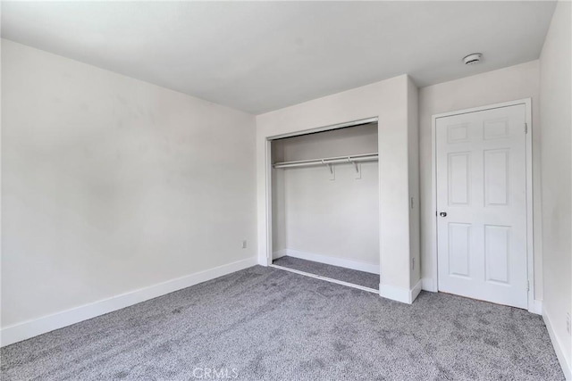 unfurnished bedroom with carpet flooring and a closet