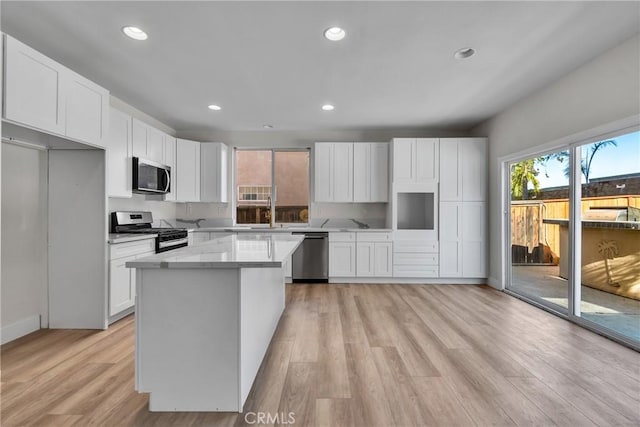 kitchen featuring a center island, light wood-type flooring, white cabinetry, and stainless steel appliances