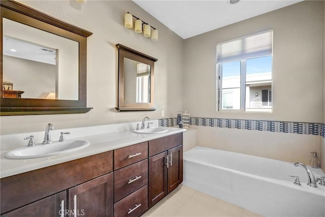 bathroom with vanity, tile patterned floors, and a tub