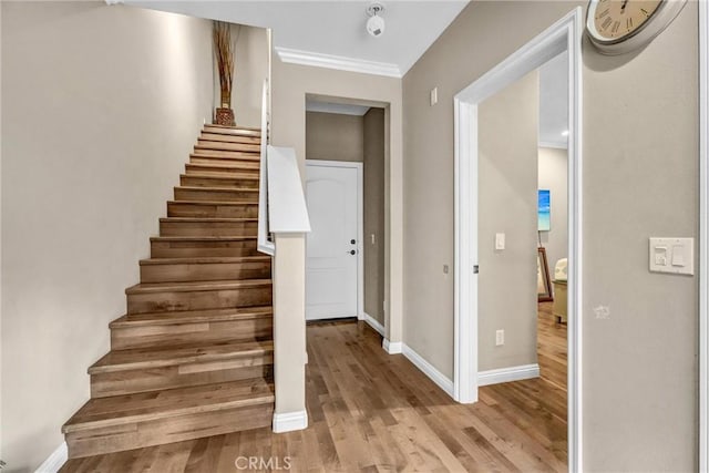 stairway featuring hardwood / wood-style floors and ornamental molding