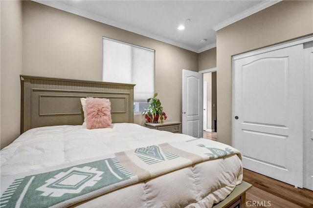 bedroom featuring hardwood / wood-style floors, a closet, and ornamental molding