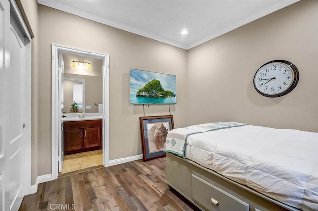 bedroom with hardwood / wood-style floors, ensuite bathroom, and ornamental molding