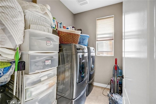 clothes washing area featuring light tile patterned flooring and independent washer and dryer