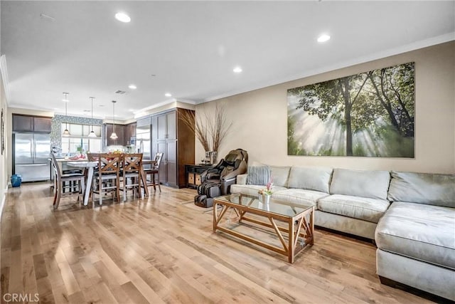 living room with light hardwood / wood-style flooring and ornamental molding