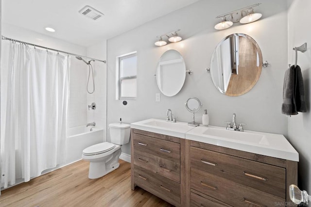 full bathroom featuring hardwood / wood-style floors, vanity, toilet, and shower / bath combo