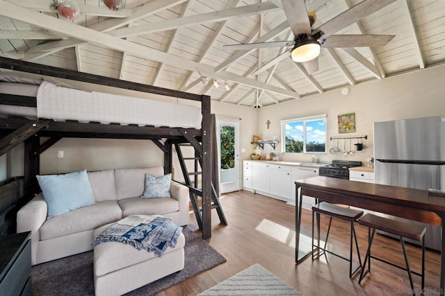 bedroom with wooden ceiling, lofted ceiling with beams, sink, light hardwood / wood-style flooring, and stainless steel refrigerator