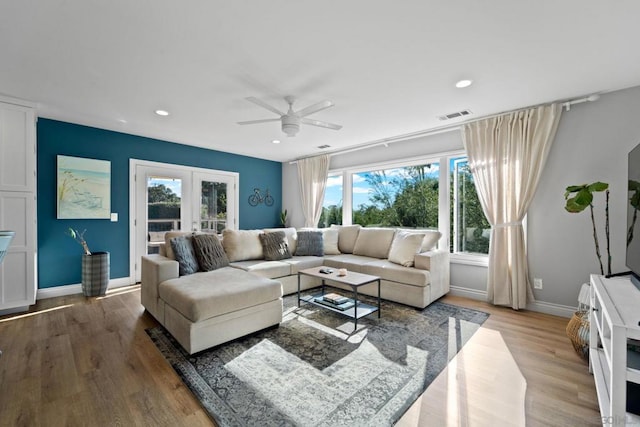 living room featuring ceiling fan, french doors, and wood-type flooring