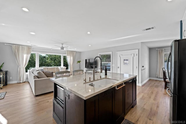 kitchen featuring dark brown cabinetry, light wood-type flooring, sink, and stainless steel appliances