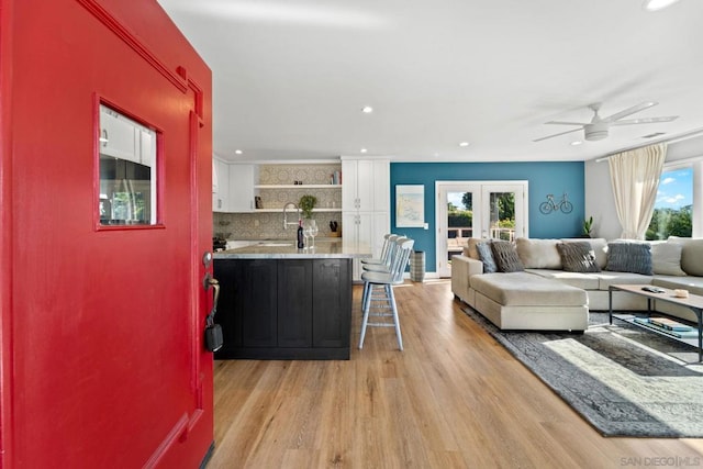 living room with plenty of natural light, ceiling fan, and light hardwood / wood-style flooring