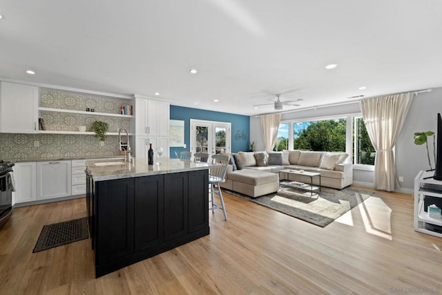 living room with ceiling fan, french doors, sink, and light hardwood / wood-style flooring