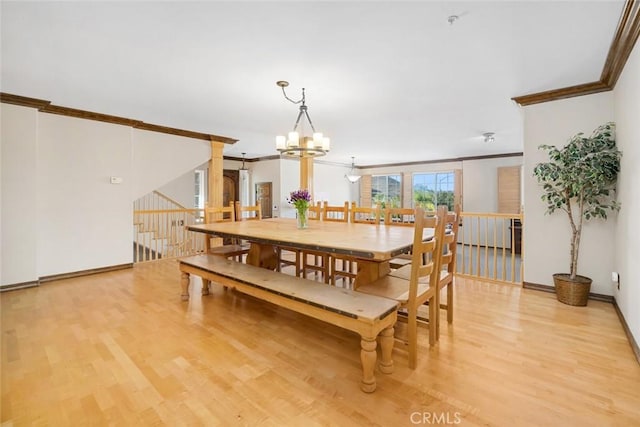 dining space with ornamental molding, a notable chandelier, and light wood-type flooring