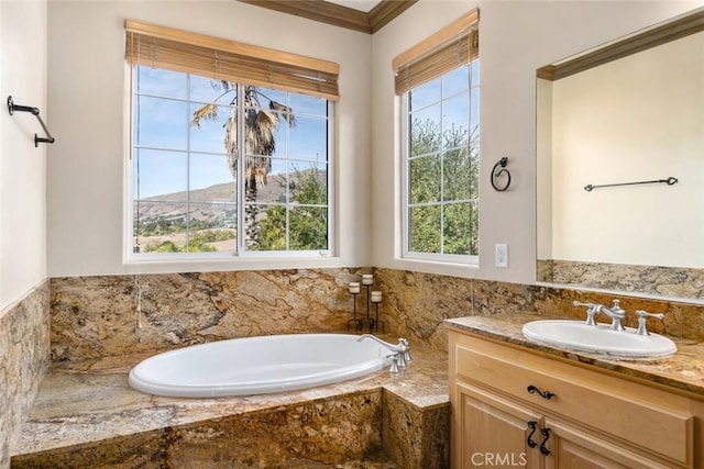 bathroom with vanity, a mountain view, ornamental molding, and tiled tub