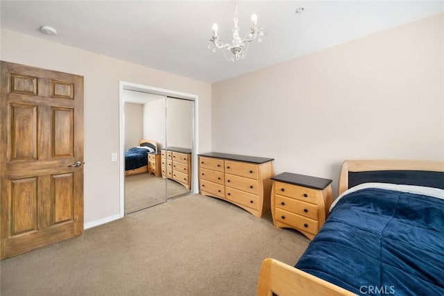 carpeted bedroom with a closet and a chandelier