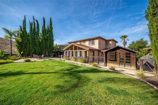 back of house with a patio area and a lawn