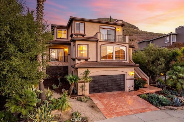 front of property with a garage and a balcony