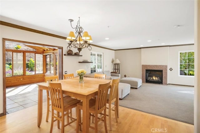 dining area with a notable chandelier, ornamental molding, and light hardwood / wood-style floors