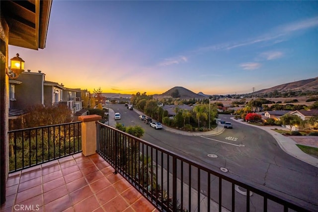 balcony at dusk featuring a mountain view