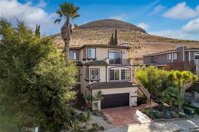 view of front of property featuring a mountain view, a garage, and a balcony