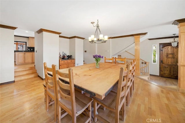 dining space featuring an inviting chandelier, crown molding, and light hardwood / wood-style floors