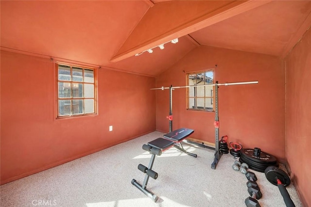 exercise room with vaulted ceiling and carpet