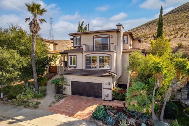 view of front of property featuring a balcony and a garage