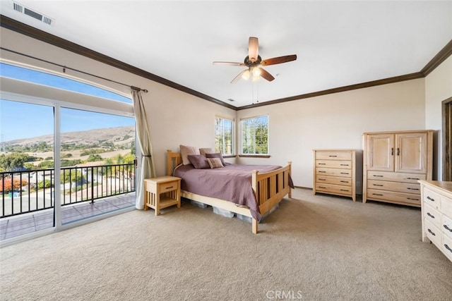 bedroom with light carpet, a mountain view, multiple windows, and access to outside