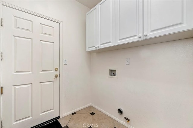 washroom with hookup for a washing machine, light tile patterned floors, and cabinets