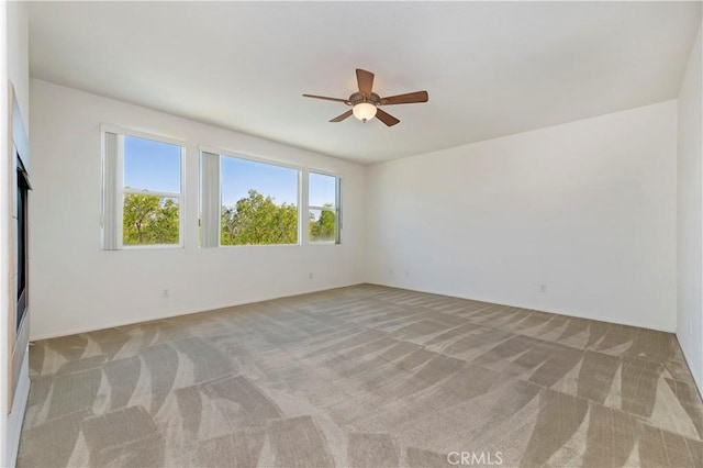 empty room with ceiling fan and light colored carpet