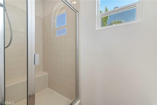 bathroom featuring a shower with shower door