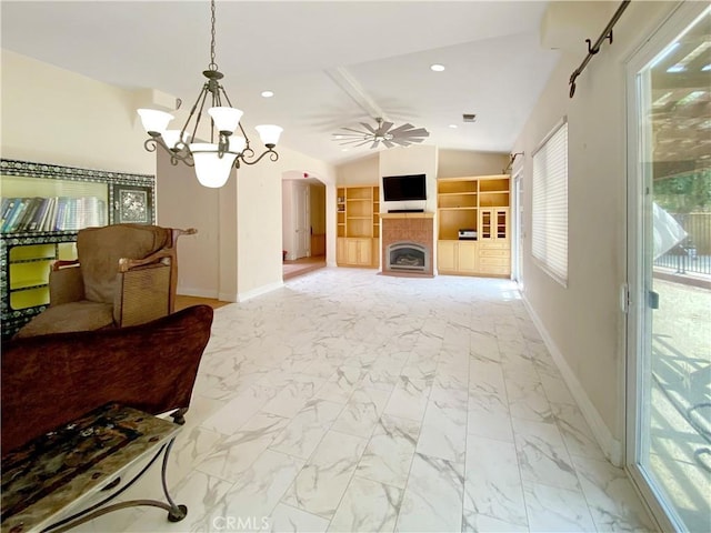 living room with lofted ceiling, arched walkways, baseboards, marble finish floor, and a tiled fireplace